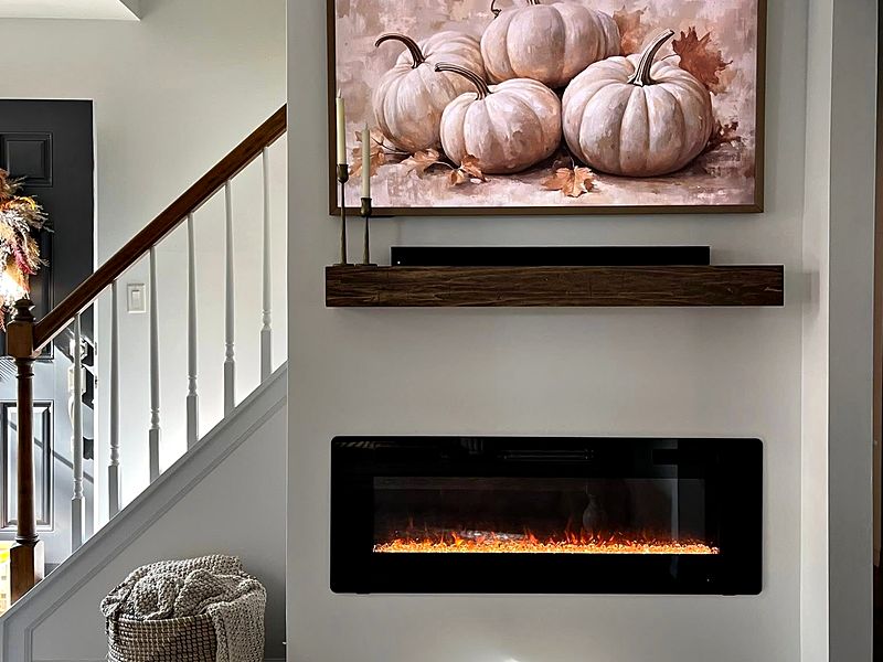 Fireplace wall with a floating wood mantel beside the staircase